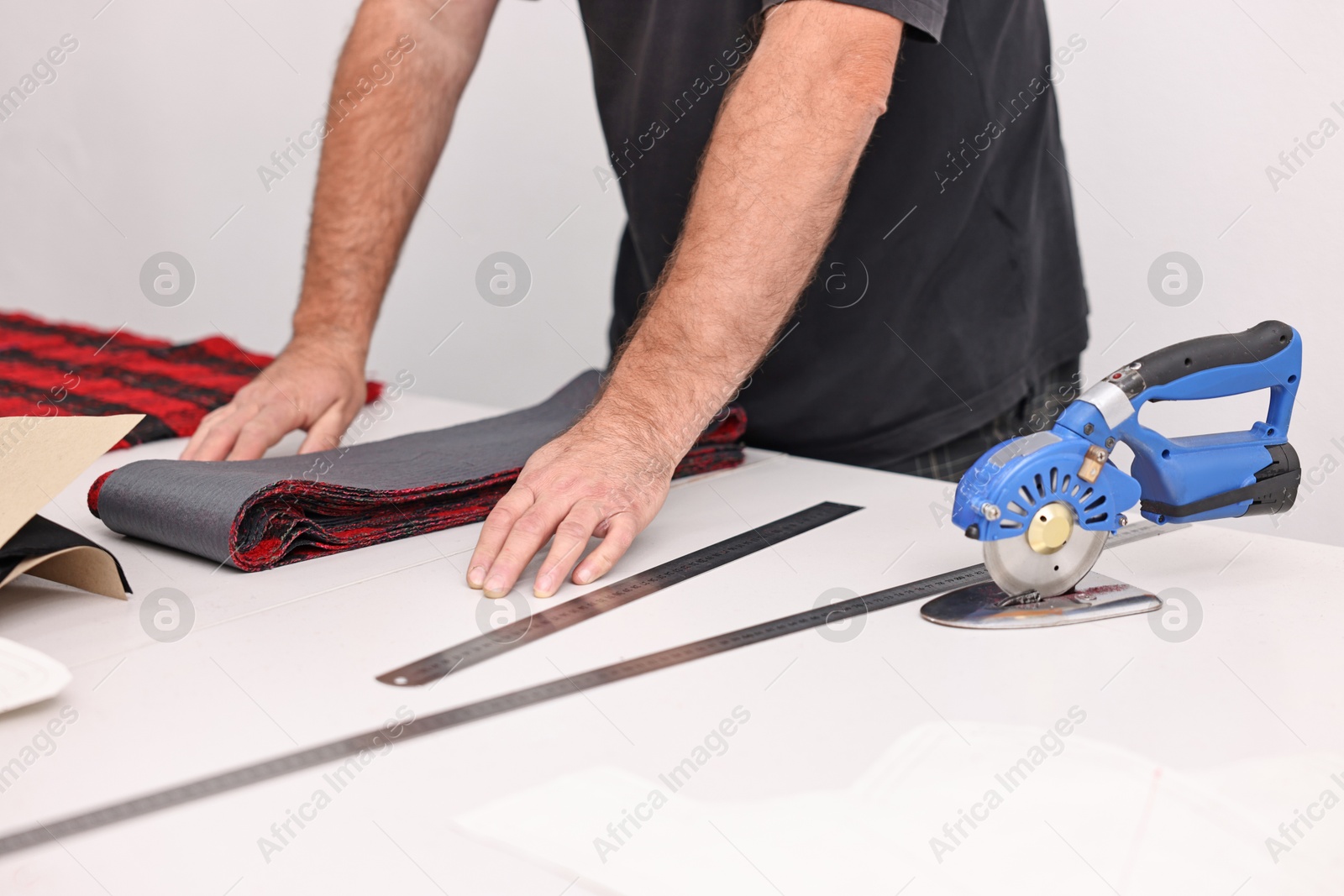 Photo of Man working at white table in professional workshop, closeup