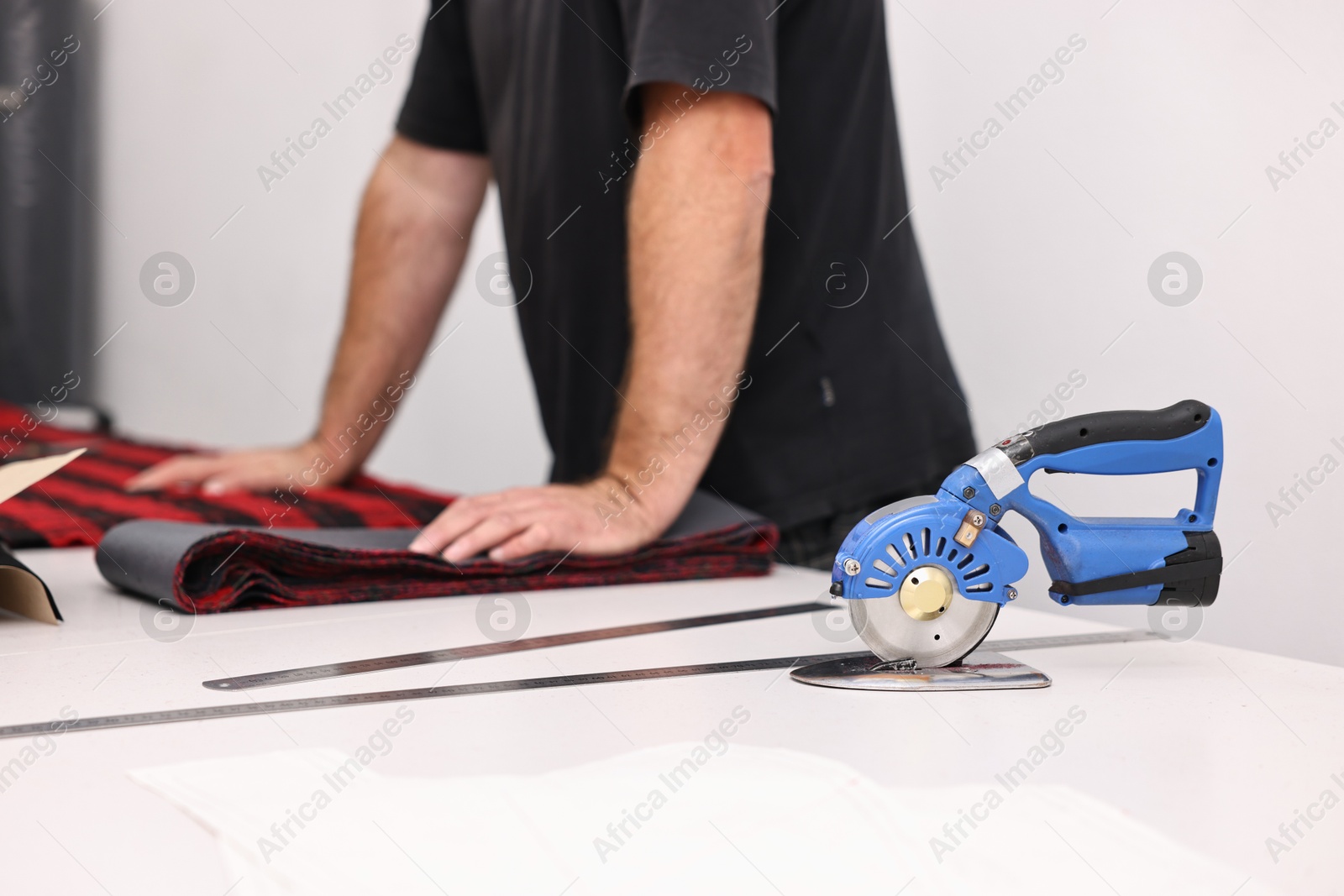 Photo of Man working at white table in professional workshop, closeup