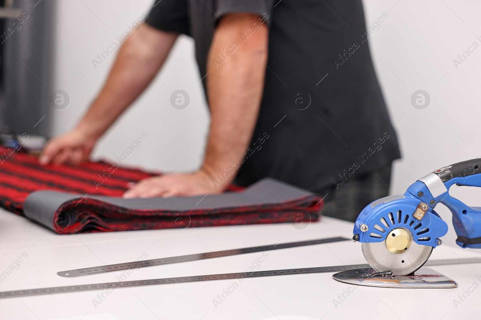 Photo of Man working at white table in professional workshop, closeup