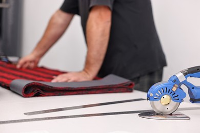 Photo of Man working at white table in professional workshop, closeup