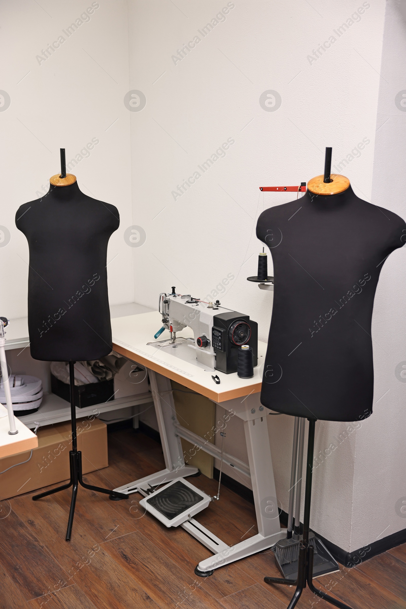 Photo of Professional workshop with sewing machine, table and mannequins