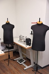 Photo of Professional workshop with sewing machine, table and mannequins