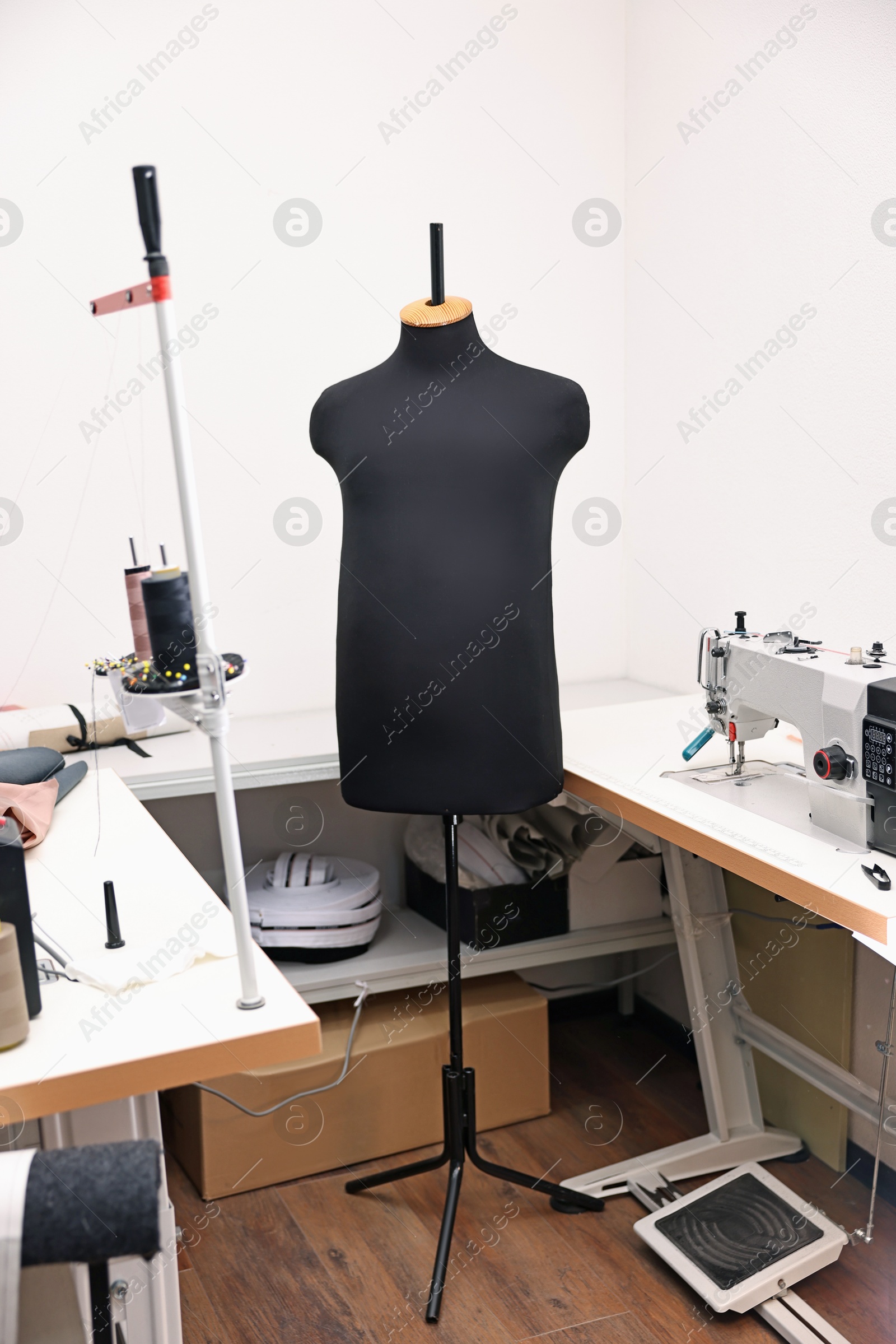 Photo of Professional workshop with sewing machine, table and mannequin