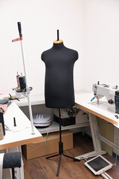 Photo of Professional workshop with sewing machine, table and mannequin