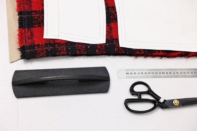 Photo of Piece of fabric, measurements, scissors and other tools on white table, top view