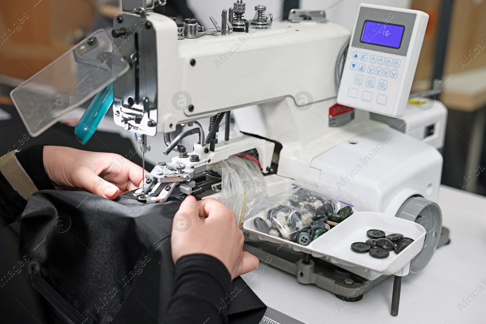 Photo of Woman working with sewing machine in professional workshop, closeup