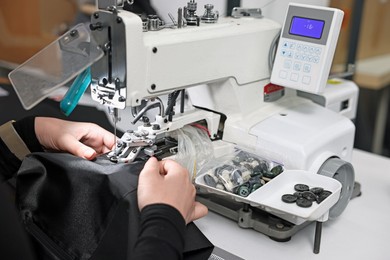 Photo of Woman working with sewing machine in professional workshop, closeup