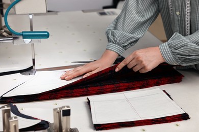 Photo of Young woman working at white table in professional workshop, closeup