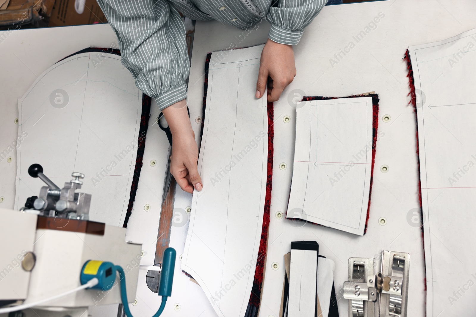 Photo of Young woman working at white table in professional workshop, closeup