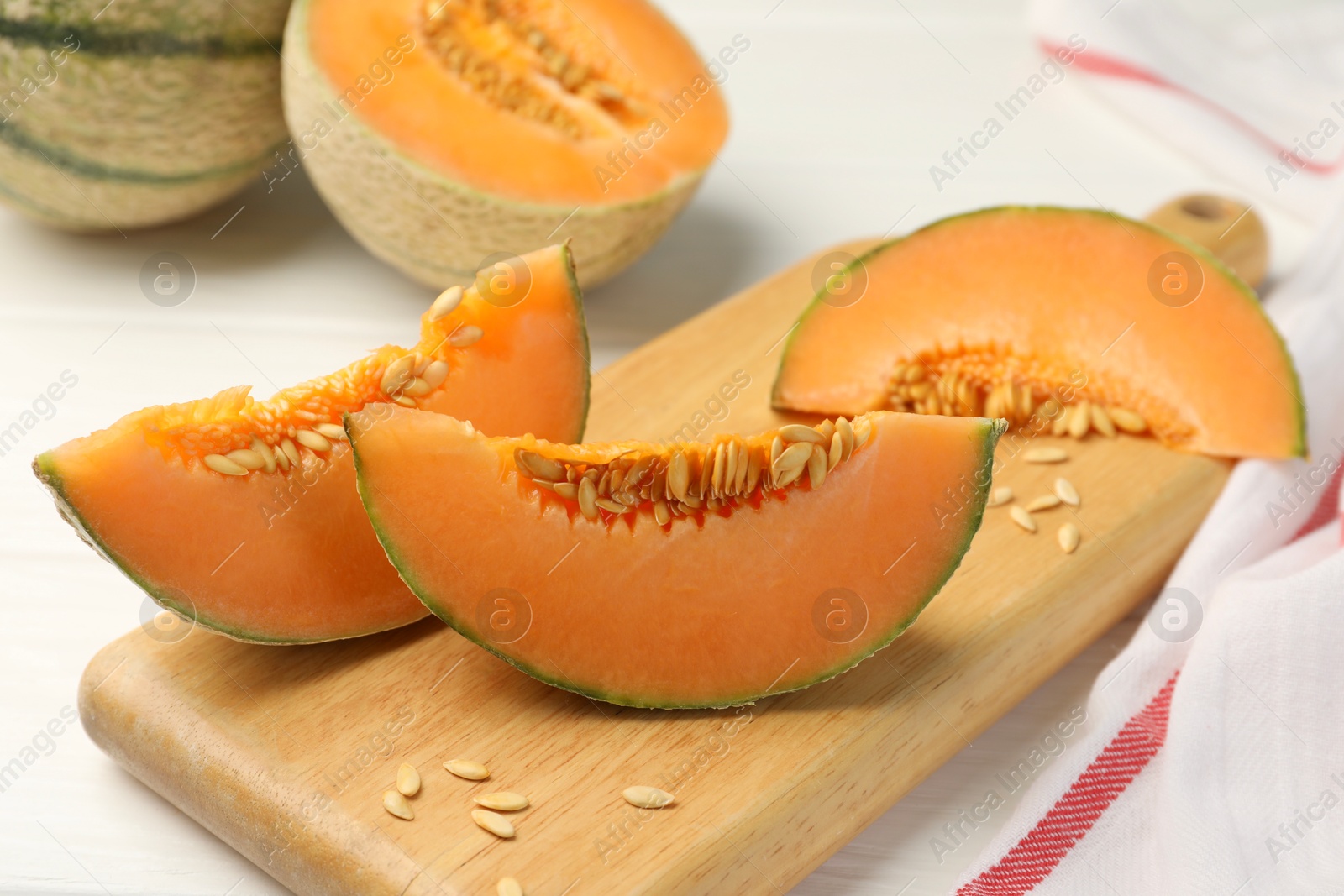 Photo of Cut ripe Cantaloupe melon on white table