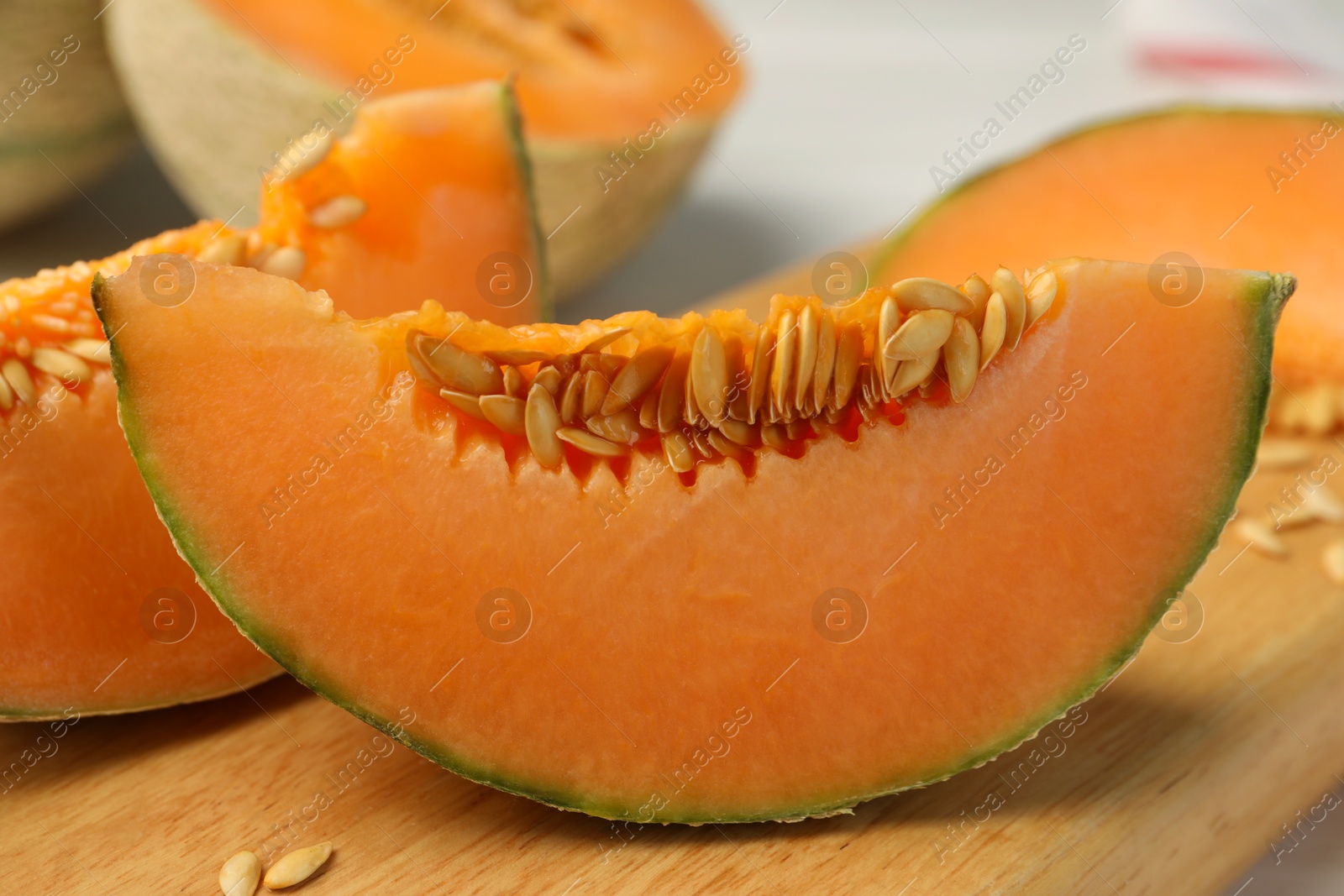 Photo of Cut ripe Cantaloupe melon on white table, closeup