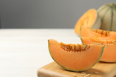 Cut ripe Cantaloupe melon on white table, closeup. Space for text