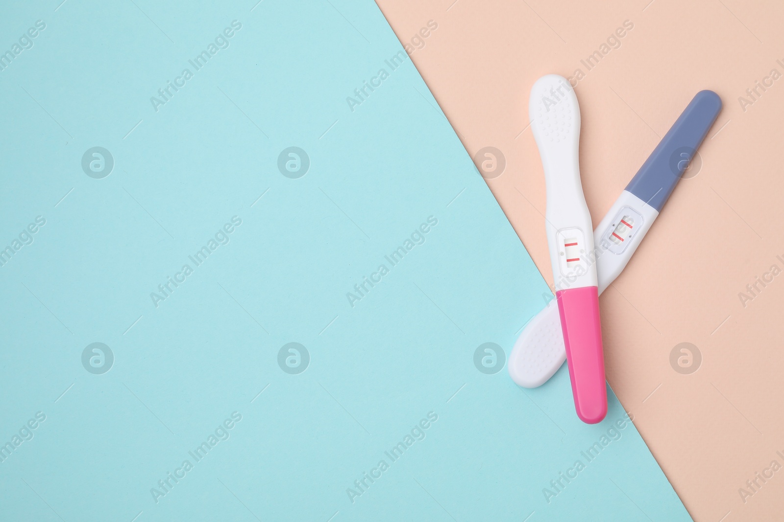 Photo of Two pregnancy tests on color background, top view. Space for text