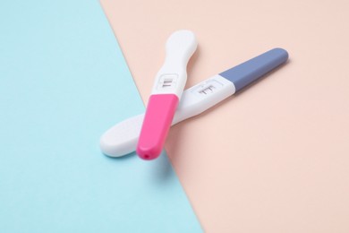 Photo of Two pregnancy tests on color background, closeup