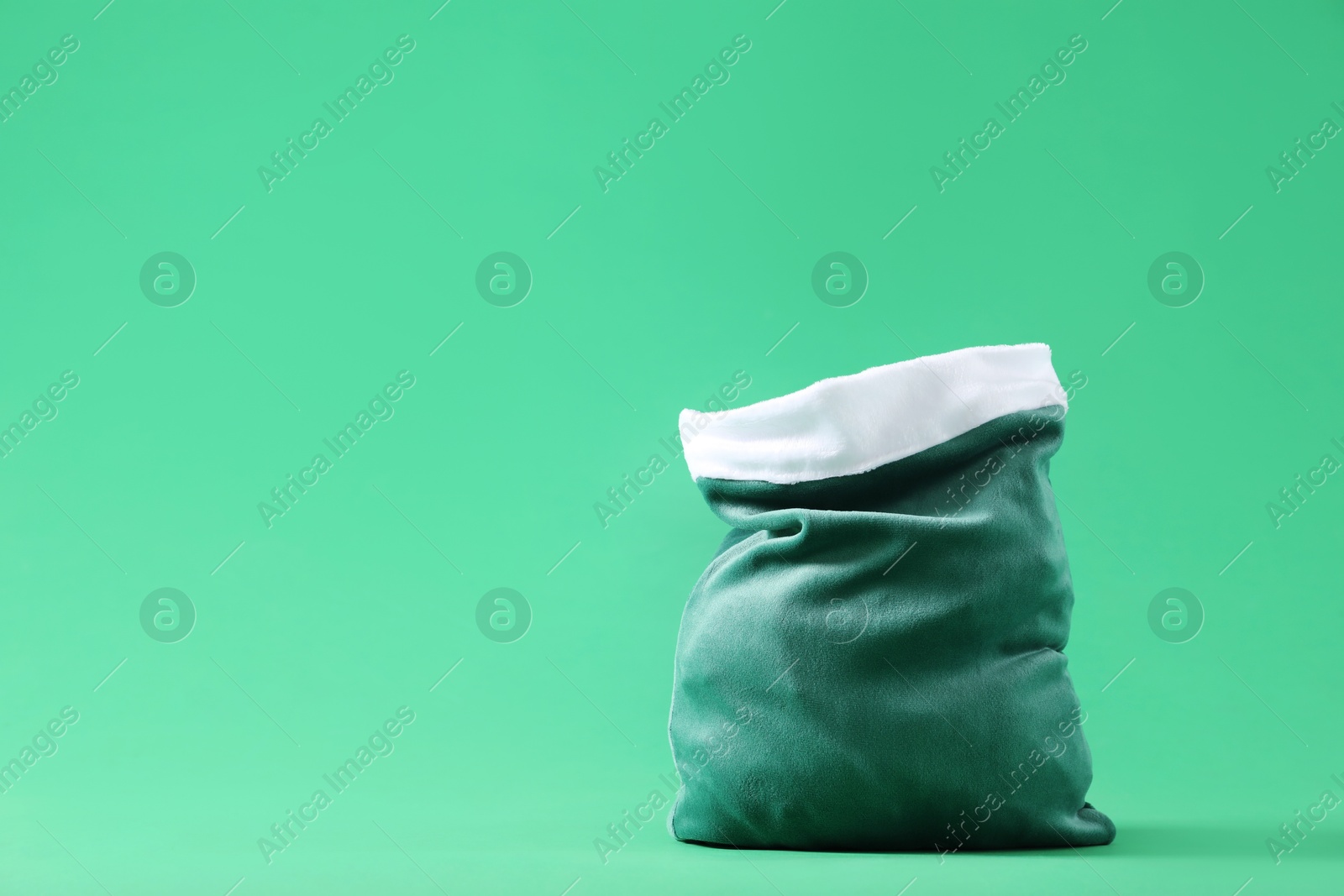 Photo of One Santa Claus bag on green background, space for text