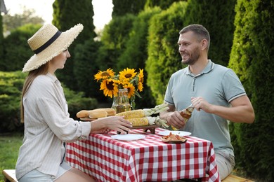 Couple having picnic at table in garden