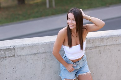 Photo of Beautiful woman wearing stylish denim shorts outdoors