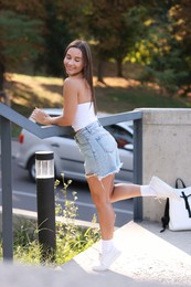 Photo of Beautiful woman wearing stylish denim shorts outdoors