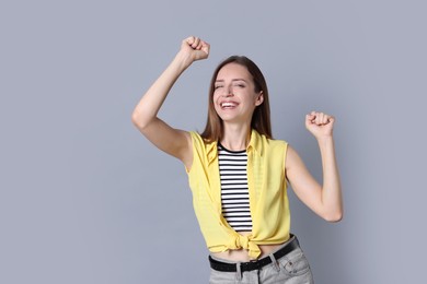 Portrait of happy winner on gray background