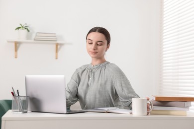 Student studying with laptop at table indoors