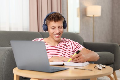 Student in headphones studying at table indoors