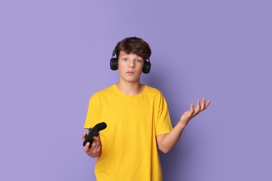 Teenage boy in headphones with controller on violet background