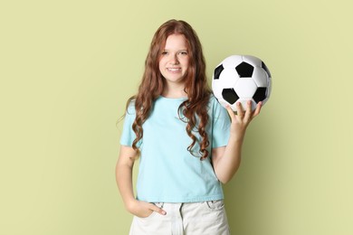 Photo of Smiling teenage girl with soccer ball on green background