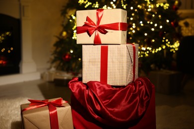 Photo of Santa bag full of Christmas presents at home, closeup