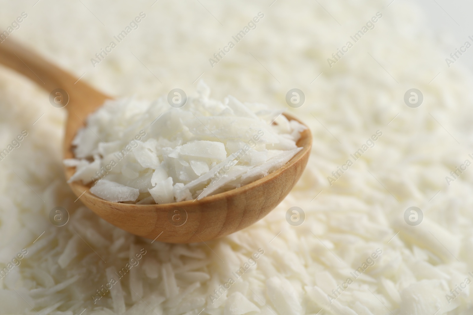 Photo of White soy wax flakes and spoon, closeup