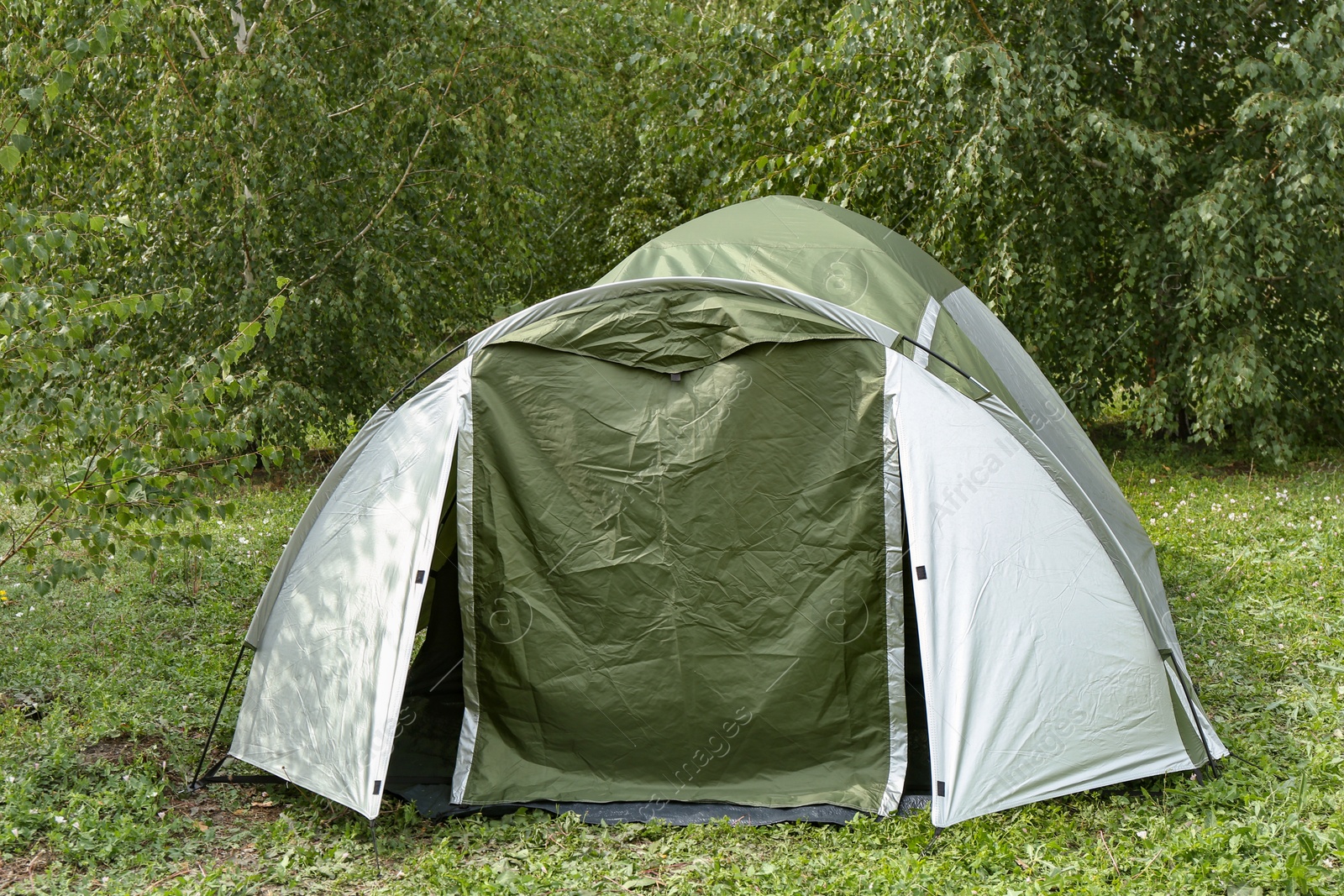 Photo of One camping tent on green grass outdoors