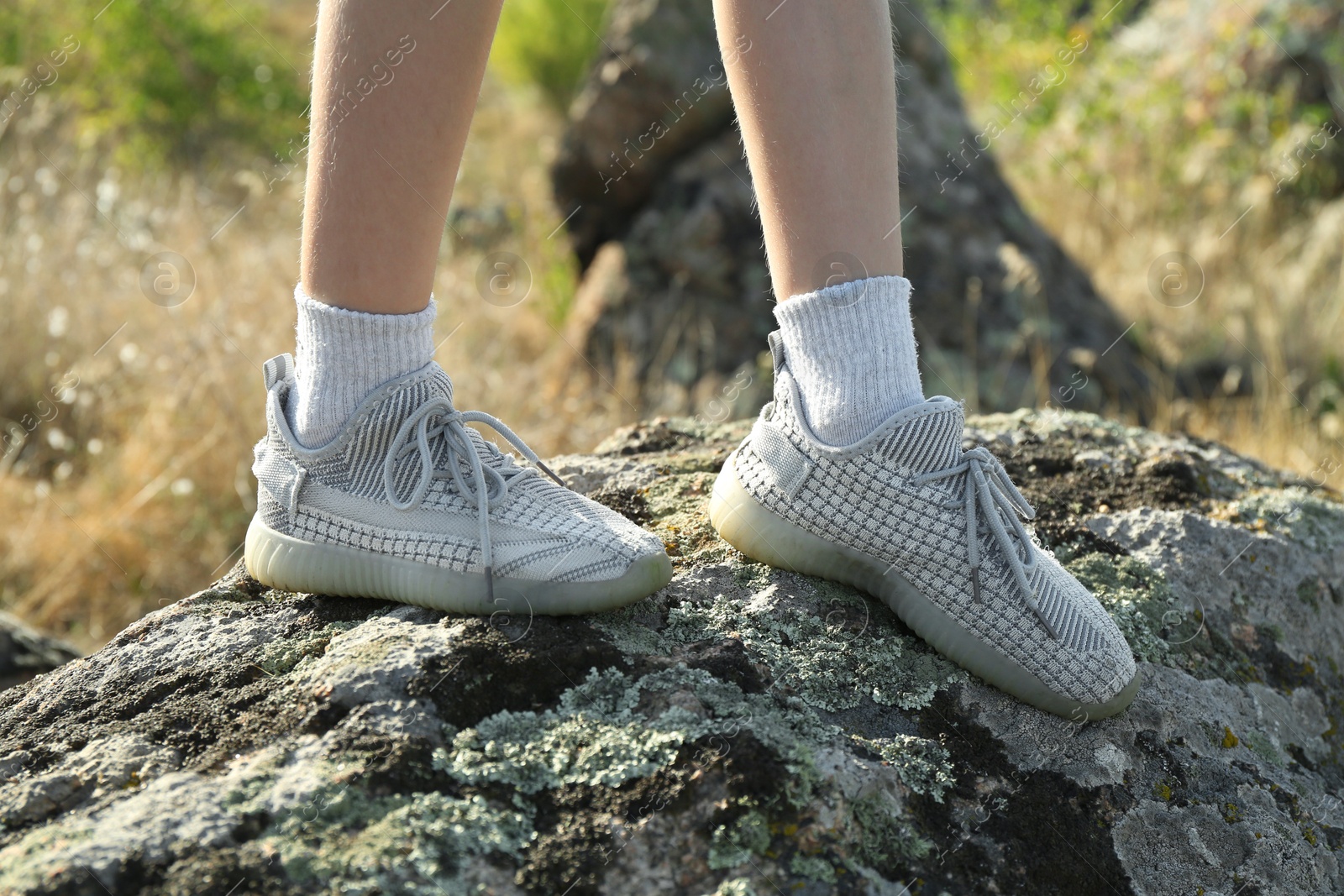 Photo of Little girl walking on stones outdoors, closeup