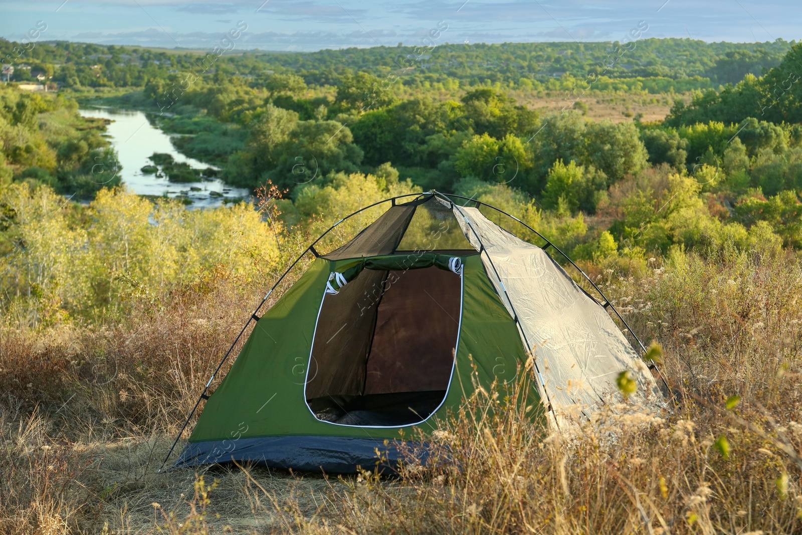 Photo of One camping tent among plants outdoors on sunny day