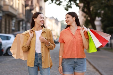 Photo of Happy women with colorful shopping bags outdoors