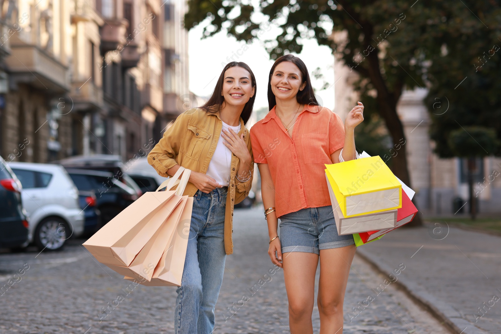 Photo of Happy women with colorful shopping bags outdoors