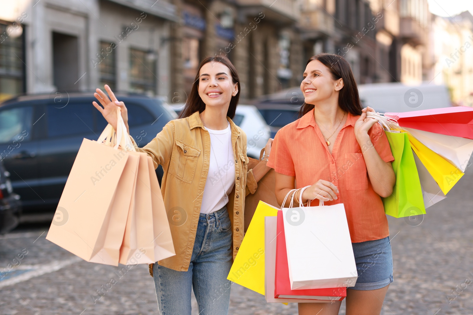 Photo of Happy women with colorful shopping bags outdoors