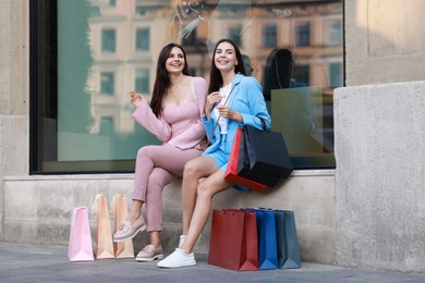 Photo of Happy women with colorful shopping bags outdoors