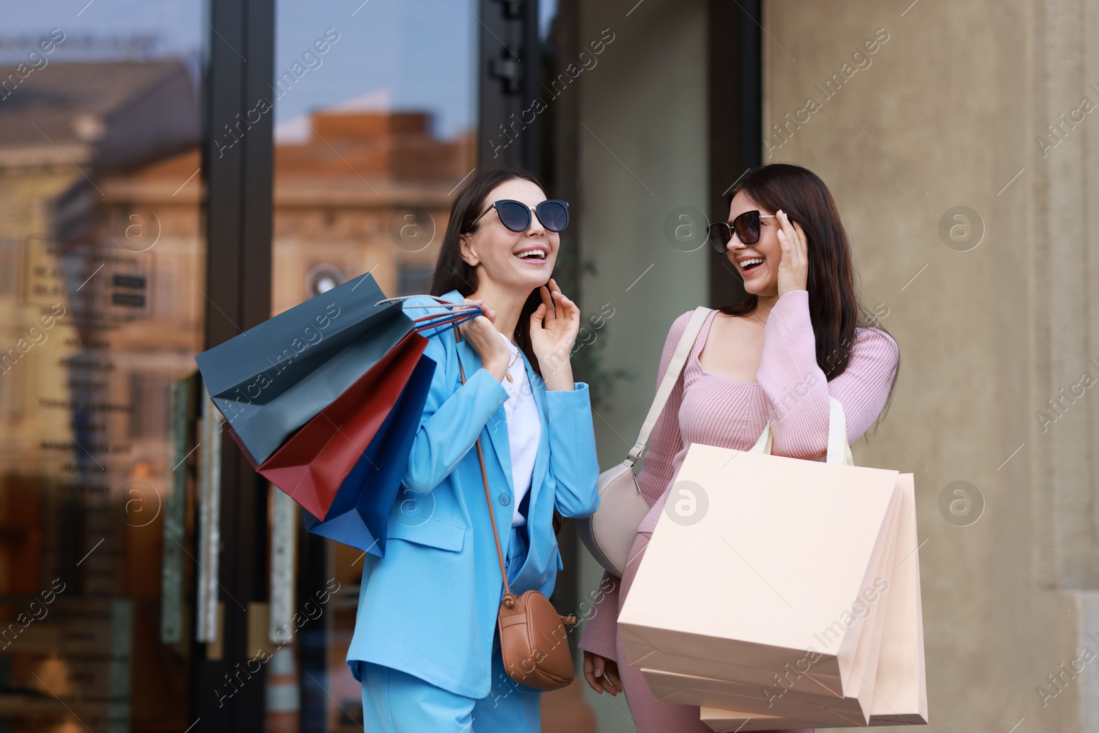 Photo of Happy women with colorful shopping bags outdoors