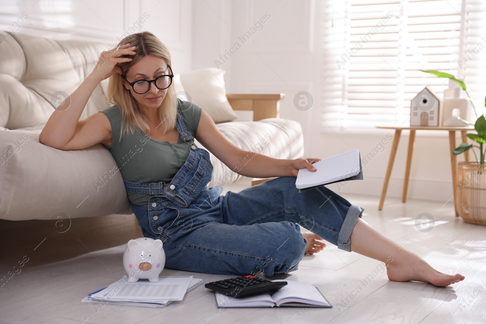 Photo of Budget planning. Woman working with accounting documents on floor indoors