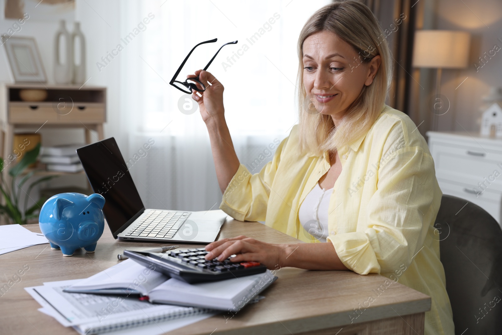 Photo of Budget planning. Woman using calculator at table indoors