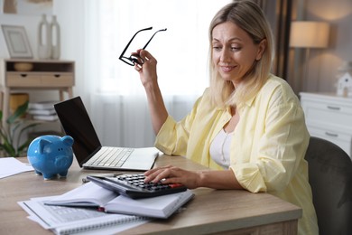 Photo of Budget planning. Woman using calculator at table indoors