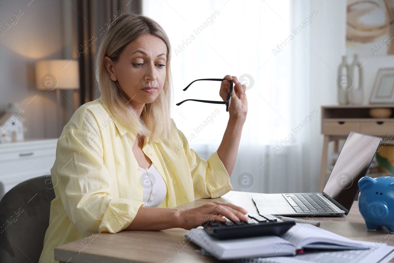 Photo of Budget planning. Woman using calculator at table indoors