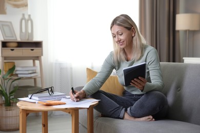 Photo of Budget planning. Woman working with accounting documents at table indoors