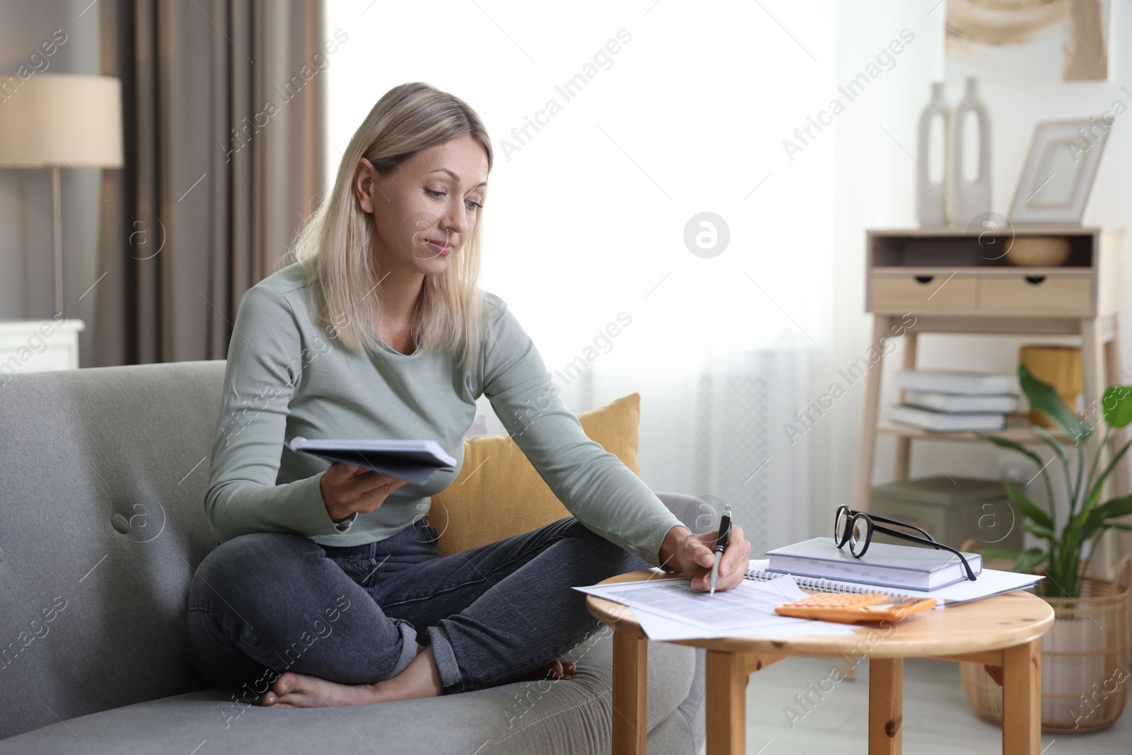 Photo of Budget planning. Woman working with accounting documents at table indoors