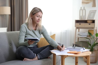 Budget planning. Woman working with accounting documents at table indoors