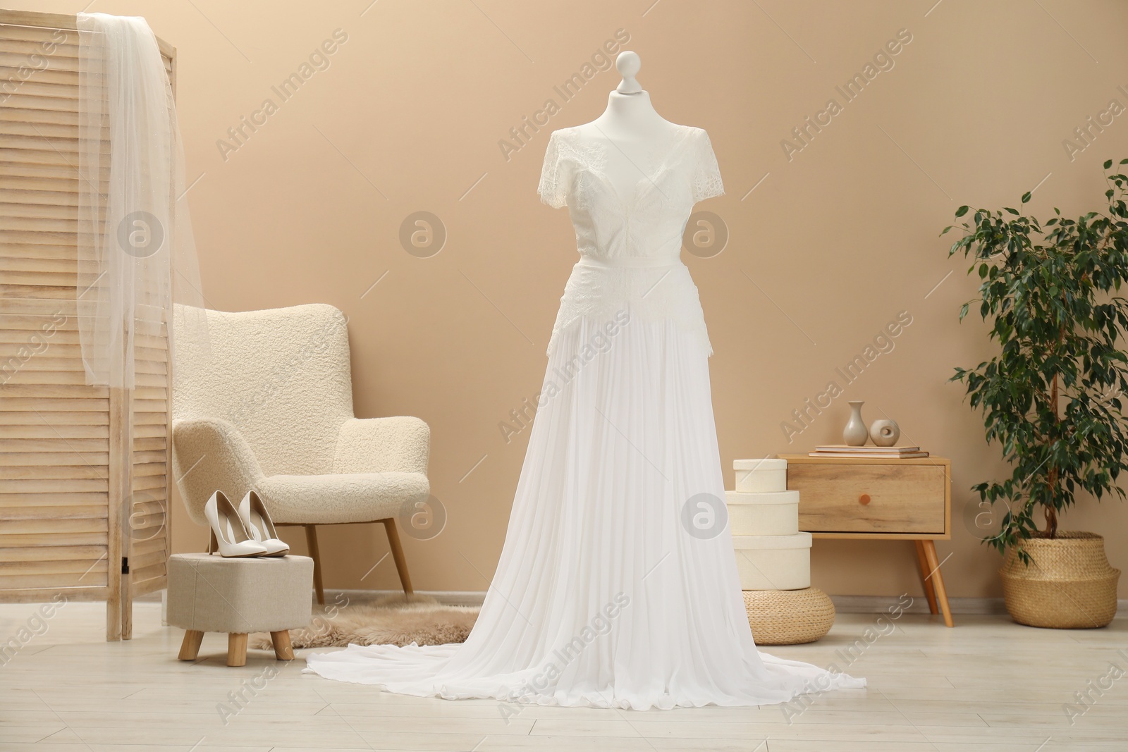 Photo of Beautiful wedding dress on mannequin and shoes in boutique