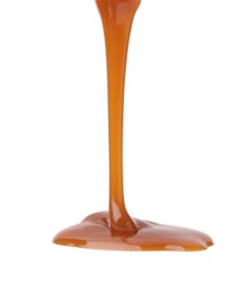 Photo of Tasty caramel sauce dripping from gravy boat on white background, closeup