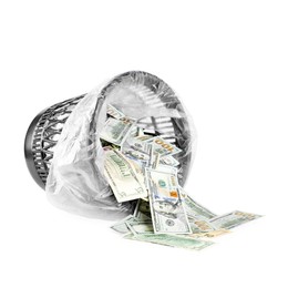 Photo of Many dollar banknotes and overturned trash bin isolated on white