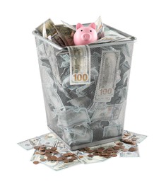 Photo of Many dollar banknotes and piggy bank in trash bin isolated on white