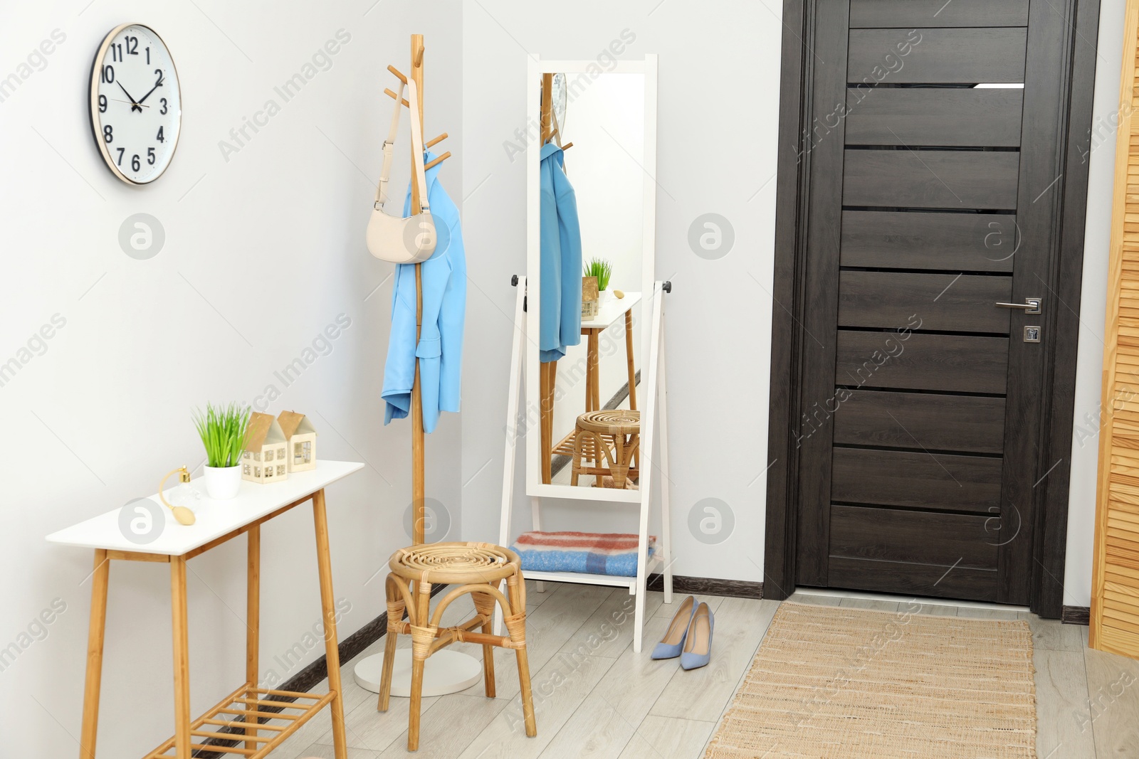 Photo of Clothing rack, mirror, storage bench and clothes in hallway