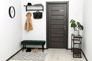 Photo of Mirror, houseplant and bench in stylish hallway